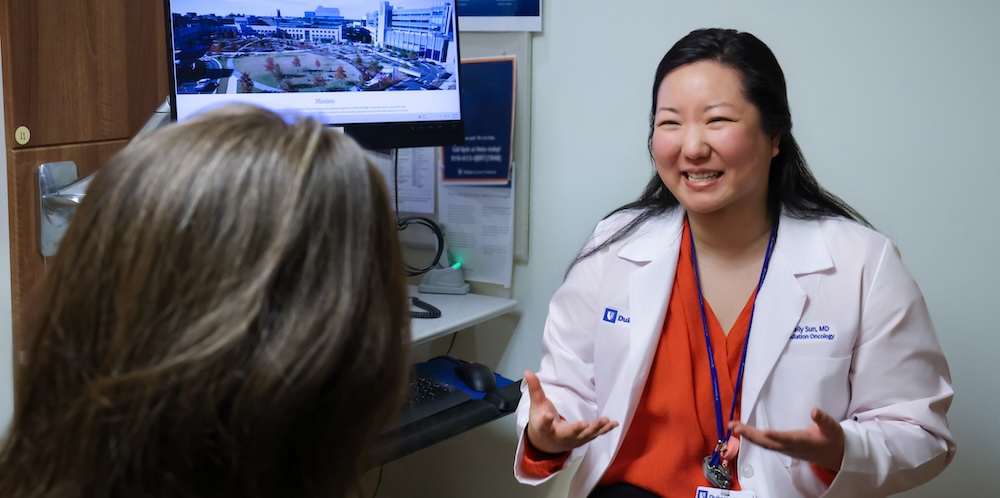 Dr. Sun talking with a patient in clinic.